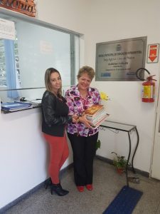 duas professoras segurando materiais posam para foto dentro de escola em Barueri
