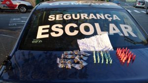porções de maconha e cocaína dispostos sobre o tampo do porta-malas de uma viatura de segurança escolar da Guarda Civil Municipal de Barueri