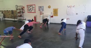 pessoas num salão praticando alongamentos