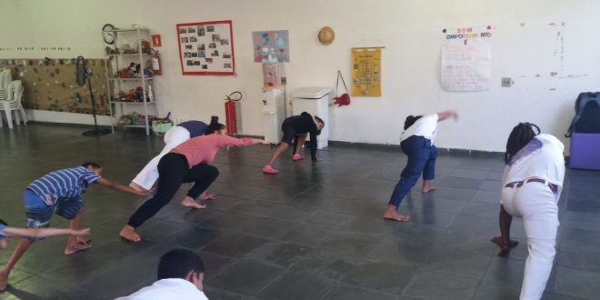 pessoas num salão praticando alongamentos