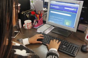 uma mulher acessa o site do Procon por meio de um notebook