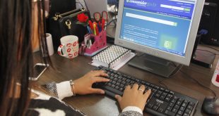 uma mulher acessa o site do Procon por meio de um notebook