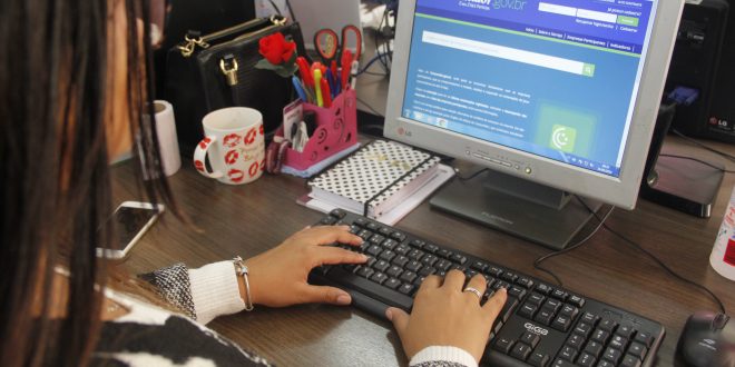 uma mulher acessa o site do Procon por meio de um notebook