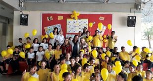 alunos e professores de escola municipal de Barueri segurando balões amarelos em campanha contra a febre amarela