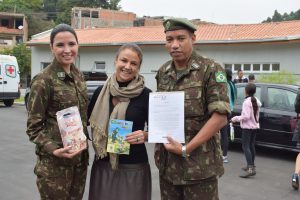 soldados do exército e mulher posam para foto durante ação em Baruei