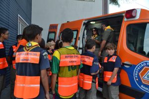 jovens do Grupo Escoteiro Amazônia de Barueri acomanham explicações de agentes da defesa civil de Barueri