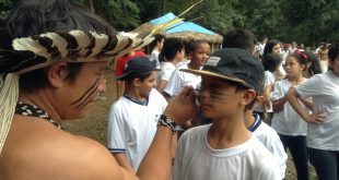 índio guarani do Sítio do Sol pinta rosto de aluno da escola Dagmar Ribas