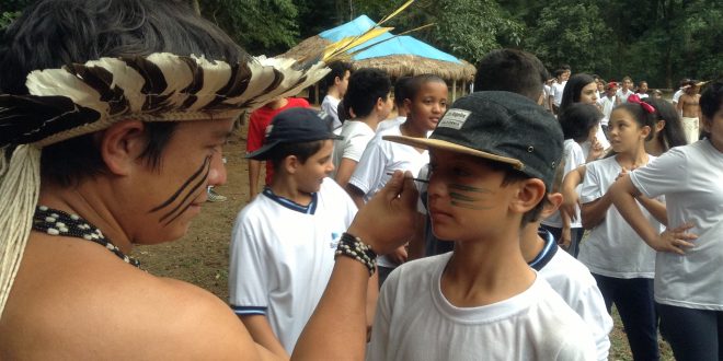 índio guarani do Sítio do Sol pinta rosto de aluno da escola Dagmar Ribas