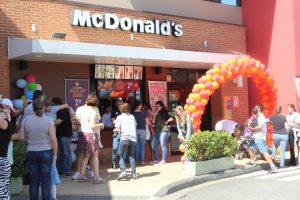 pessoas reunidas em frente a uma unidade do McDonald's durante o McDia Feliz
