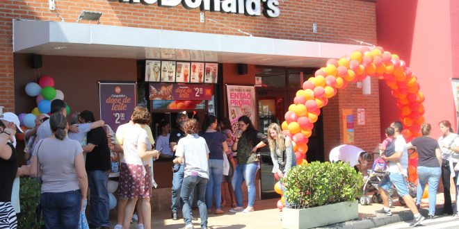 pessoas reunidas em frente a uma unidade do McDonald's durante o McDia Feliz