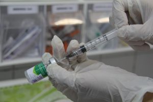 mão de um médico preparando uma vacina contra a gripe