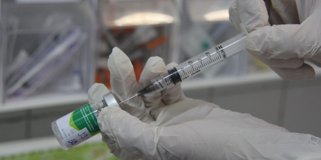 mão de um médico preparando uma vacina contra a gripe