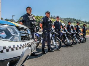 guardas municipais nas ruas de Santana de Parnaíba posam ao lado de suas viaturas
