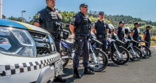 guardas municipais nas ruas de Santana de Parnaíba posam ao lado de suas viaturas