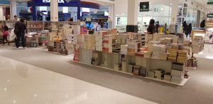pilhas de livros em quiosques da feira de livros Promo Livros no Parque Shopping Barueri
