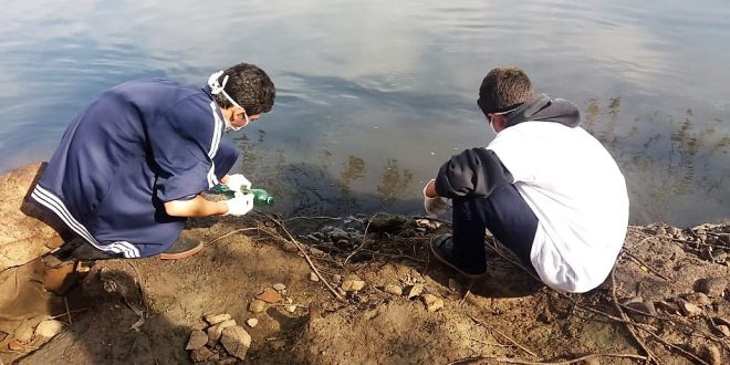 dois alunos da Emef Alexandrino da Silveira Bueno colhem amostras de água do Rio Tietê em Salto