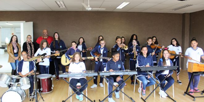 alunos tocam diversos instrumentos, incluindo bateria, xilofgone, teclado, violino, baixo e guitarra, na teclado na Emef Eizaburo Nomura, em Barueri