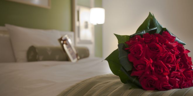 detalhe de uma rosa sobre uma cama de hotel