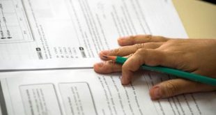 mão de um ou uma estudante sobre o caderno de questões do vestibular da Fatec