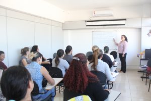cerca de 20 adultos acompanhando uma aula de um curso profissionalizante