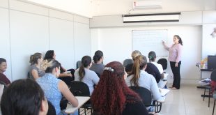 cerca de 20 adultos acompanhando uma aula de um curso profissionalizante
