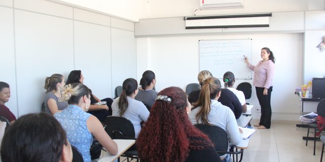 cerca de 20 adultos acompanhando uma aula de um curso profissionalizante