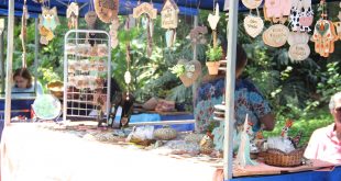 um estande da feira de artes, decoração e artesanato, com diversos objetos de artesanato pendurados e dispostos