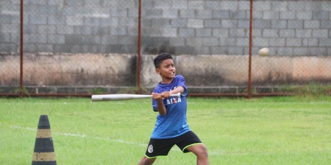 aluno do Barueri Esporte Forte prestes a atingir uma bola de beisebol com seu taco