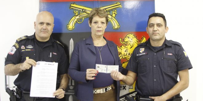 a secretária de Segurança e Mobilidade Urbana de Barueri Regina Mesquita e dois guardas civis exibem as novas carteiras de identidade funcional da categoria