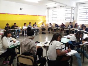alunos sentados em suas carteiras em roda em sala de aula da Emef Lenio