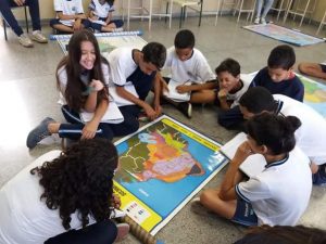 alunos sentados em volta de um mapa na Emef Lenio