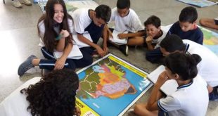 alunos sentados em volta de um mapa na Emef Lenio