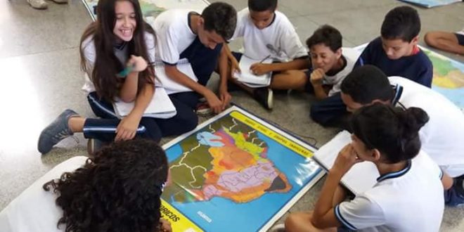 alunos sentados em volta de um mapa na Emef Lenio