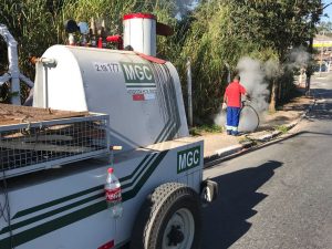 caminhonete com o herbicida ecológico e um homem aplicando-o ao fundo