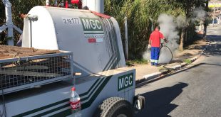 caminhonete com o herbicida ecológico e um homem aplicando-o ao fundo