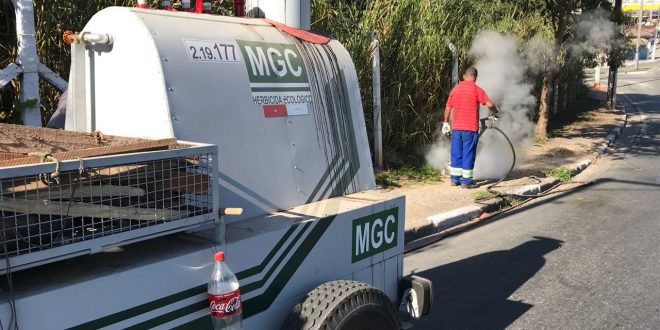 caminhonete com o herbicida ecológico e um homem aplicando-o ao fundo