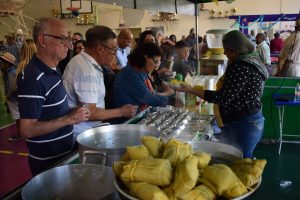 idosos se servem de pamonha durante Festa Julina do Parque da Maturidade