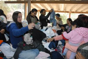 cidadças vasculham pilha de roupas para selecionar peças