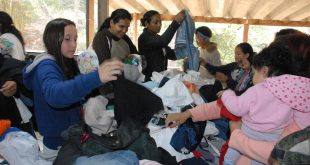 cidadças vasculham pilha de roupas para selecionar peças