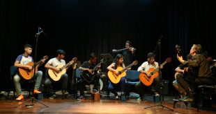 um grupo de alunos se apresentando ao violão