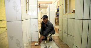 um pedreiro colocando um piso