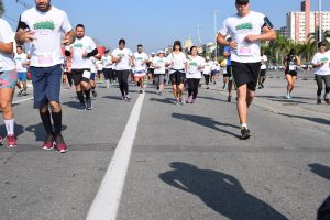 participantes da corrida do graacc passam pelos lados da câmera