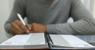 uma pessoa escrevendo em uma agenda,; sua cabeça não é mostrada