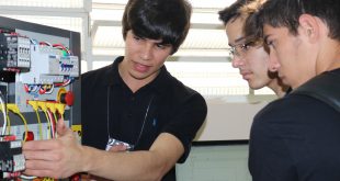 estudante explica instalação tecnológica para dois visitantes durante ExpoTec