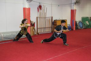 dois atletas de kung fu praticam movimentos