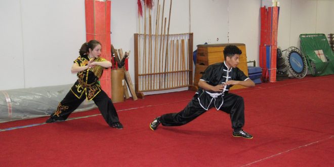 dois atletas de kung fu praticam movimentos