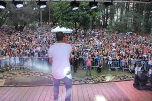 projota fotografado de costas com grande público visível ao fundo