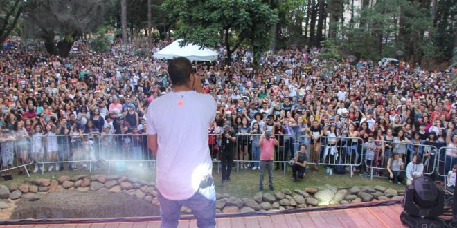 projota fotografado de costas com grande público visível ao fundo