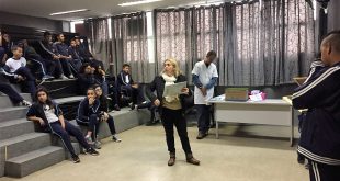 alunos sentados na plateia enquanto professora organiza o quiz