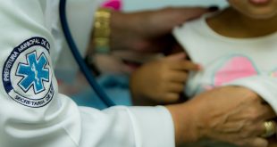 uma criança cujo rosto não é mostrado sendo examinada por um(a) médico(a) em barueri